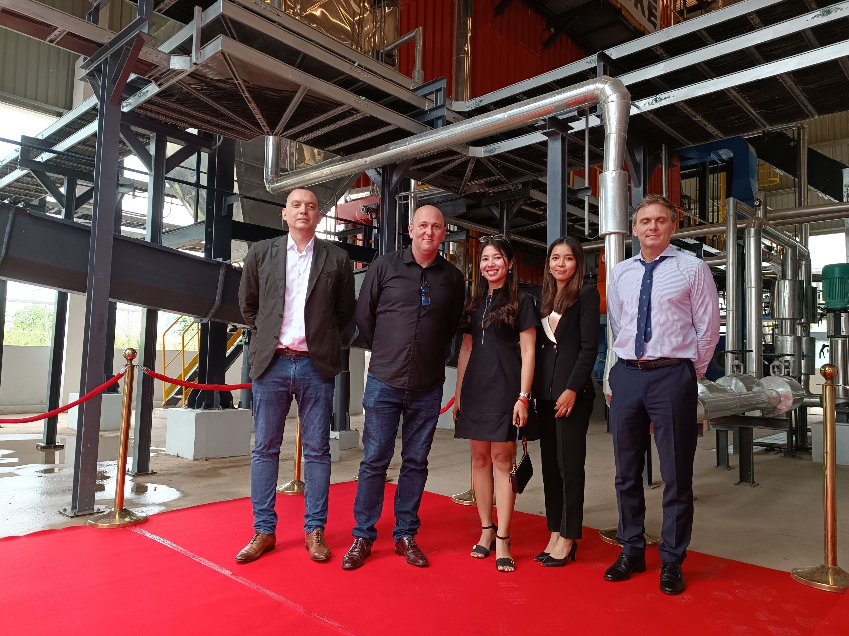 Rob Santler (right) at the Heineken Cambodia biomass plant inauguration, Phnom Penh — rice-husk-fired water-tube steam boiler infrastructure visible behind