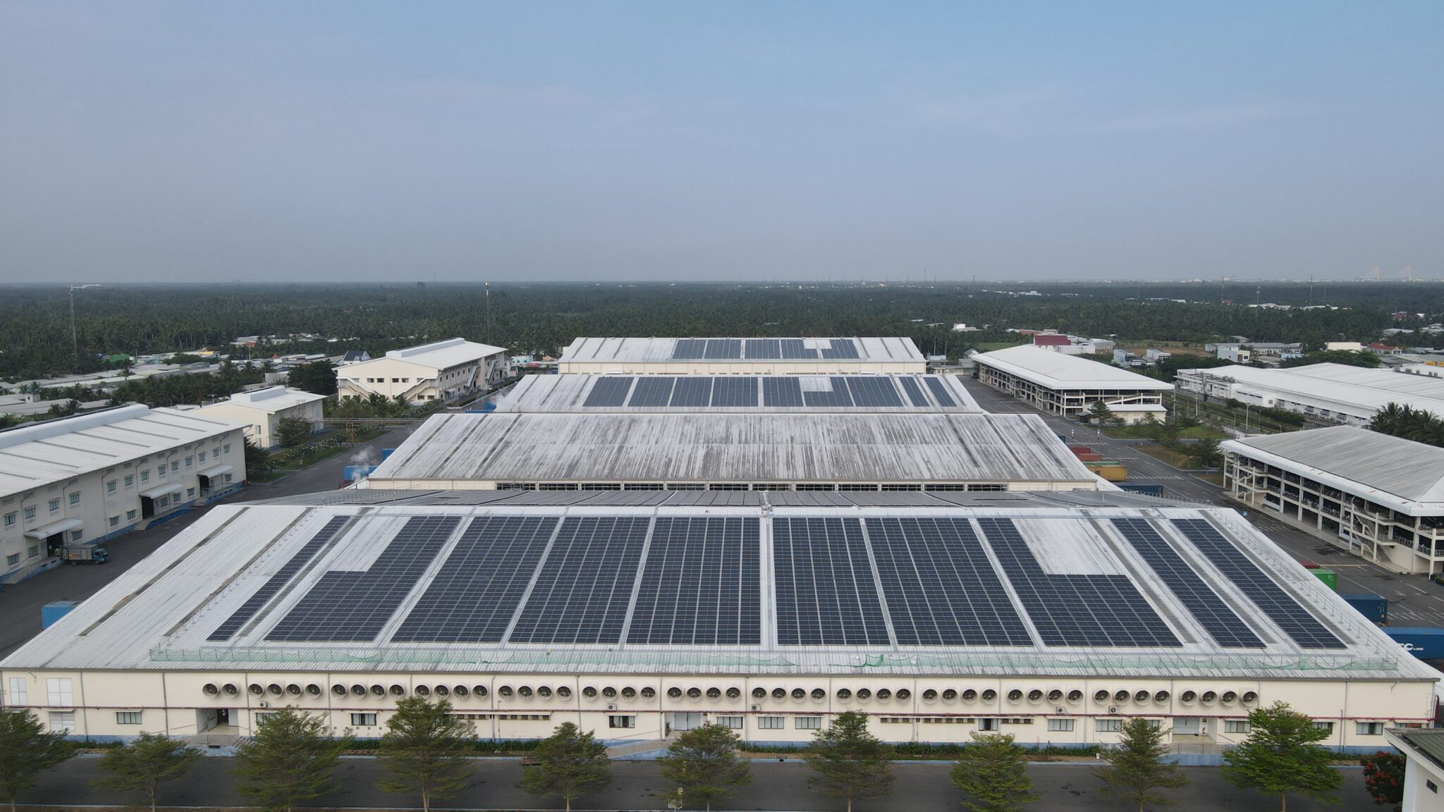 Vietnamese textile factory rooftop solar — Mekong Delta industrial estate, drone aerial